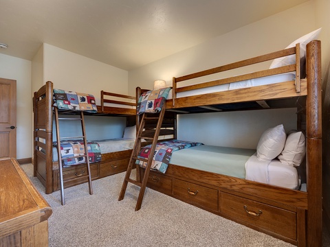 Your kids will love the twin bunk beds with colorful quilts and built-in storage drawers, perfect for families looking to maximize sleeping space in this cozy, warm mountain retreat.