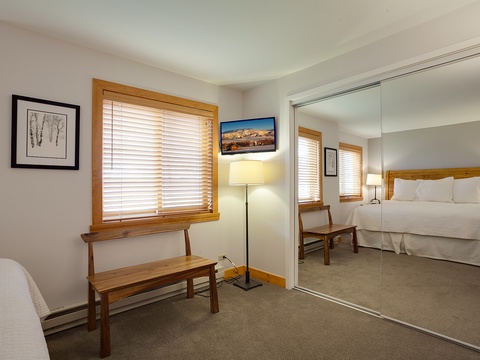 Your peaceful bedroom features warm wood tones, plush bedding, and a mirrored closet that opens up the space, creating your restful mountain retreat.