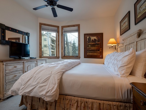 Wake up refreshed in this cozy bedroom with soft linens, warm wood accents, and natural mountain light. The bedside lamp sets a gentle glow as you unwind after your day.