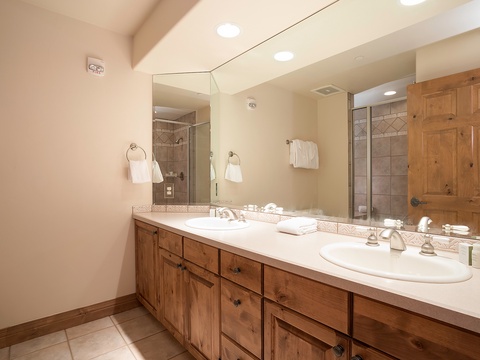 Freshen up in your private bathroom with a spacious vanity, plush towels, and a modern tiled shower for your ultimate comfort and convenience.