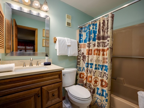 Your private bathroom offers fresh linens, a spacious vanity, and a charming Southwestern-inspired shower curtain—everything you need to feel right at home.