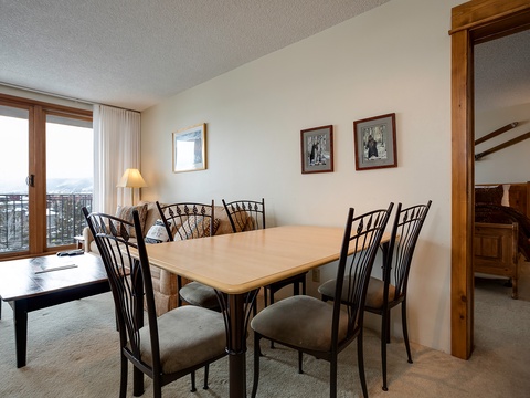 Gather around the dining table with mountain views stretching beyond your window, where every meal feels like a special occasion in this inviting space.