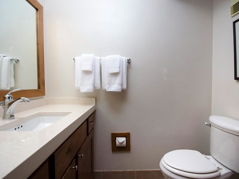Your private bathroom features crisp white linens, warm wood cabinetry, and everything you need to refresh after a day exploring the area.