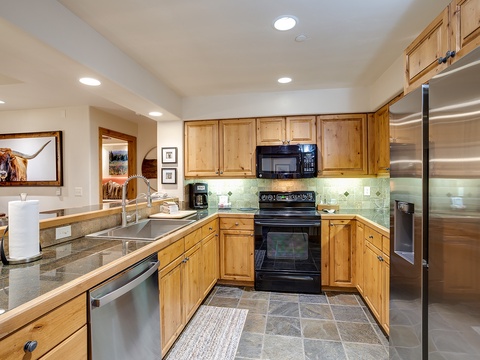 Your fully equipped kitchen features warm wood cabinetry, granite counters, and modern stainless appliances, making meal prep a breeze during your stay.