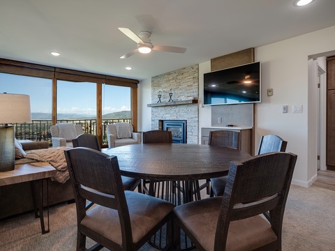Gather around the spacious dining table while natural light streams through expansive windows, framing stunning mountain vistas that make every meal memorable in your modern, thoughtfully designed retreat.