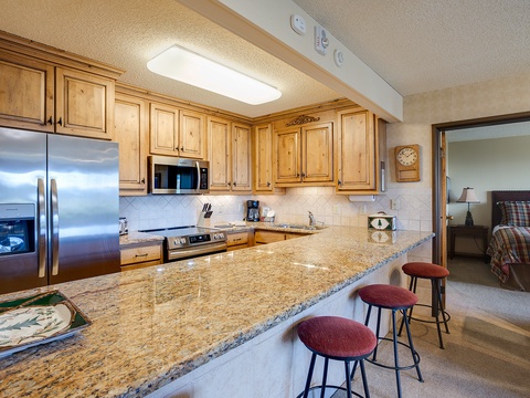 Your fully equipped kitchen features granite counters, stainless appliances, and breakfast bar seating—perfect for preparing meals and gathering with loved ones during your stay.