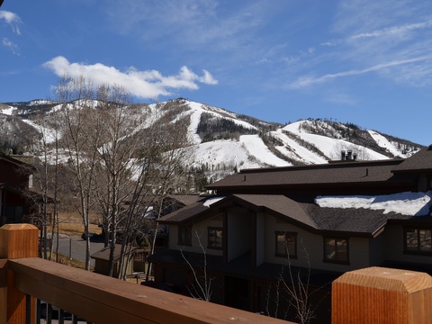 This mountain resort offers stunning ski slope views with snowy peaks rising above surrounding alpine buildings, creating a perfect winter getaway backdrop.