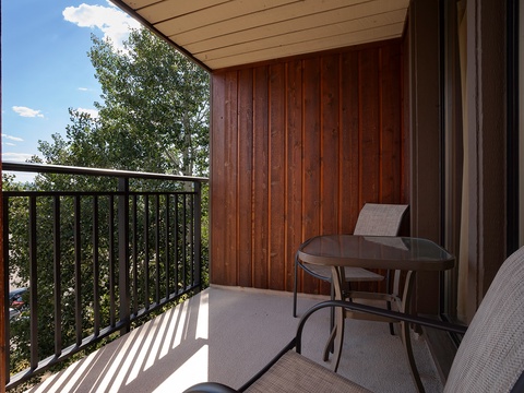 Step out onto your private balcony with warm wood accents and comfy seating, where you can sip morning coffee or unwind with treetop views overhead.