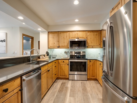 Your chef-worthy kitchen awaits with gleaming stainless steel appliances, warm wood cabinetry, and sleek granite countertops—perfect for whipping up mountain meals or morning coffee.