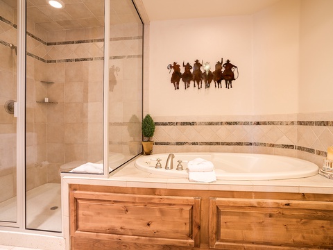Soak your cares away in your own elegant bathroom featuring a deep soaking tub, walk-in shower, and charming Western touches that set the perfect tone for relaxation.