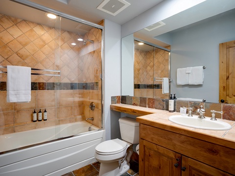 Unwind in your inviting bathroom with a soothing bath or refreshing shower, surrounded by warm wood accents and thoughtful amenities.