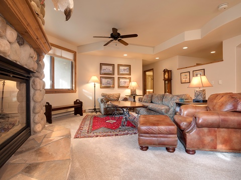 Sink into plush leather seating by your own stone fireplace, where mountain-inspired charm meets modern comfort in this spacious living area.