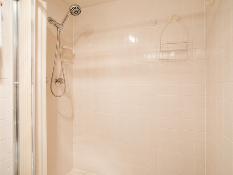 Step into this sparkling clean, tiled shower with dual showerheads and convenient storage caddy—your refreshing escape awaits after each day's adventures.