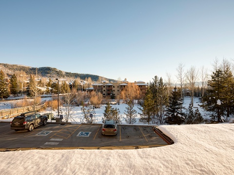 Winter mountain community setting with accessible parking, snow-covered trees, and scenic slopes offering a peaceful seasonal backdrop for your alpine getaway.