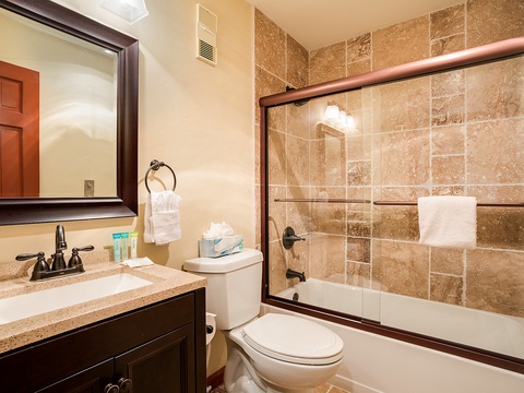 Step into your private bathroom with elegant tile work, a spacious tub-shower combo, and fresh towels awaiting your arrival.