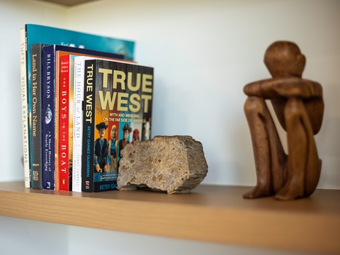Personal touches bring warmth to your space—a curated bookshelf with travel reads and thoughtful decor invites you to unwind and explore new stories.
