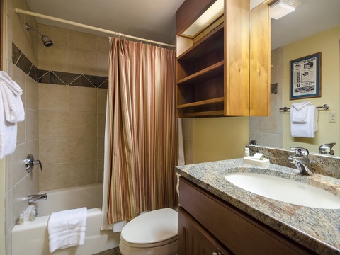 Your private bathroom features a granite vanity, plush towels, and a tiled tub-shower combo—everything you need to refresh and relax in comfort.