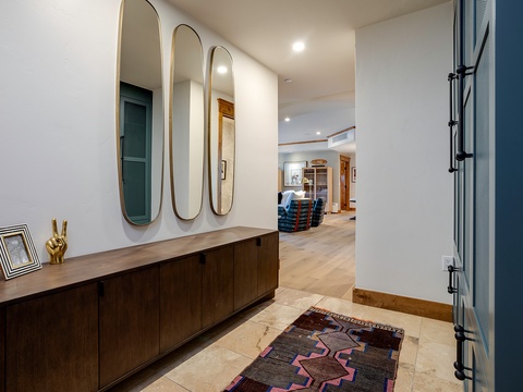 Step through your private entrance into a stylishly designed foyer with sleek mirrors and warm wood tones, opening to airy living spaces beyond.
