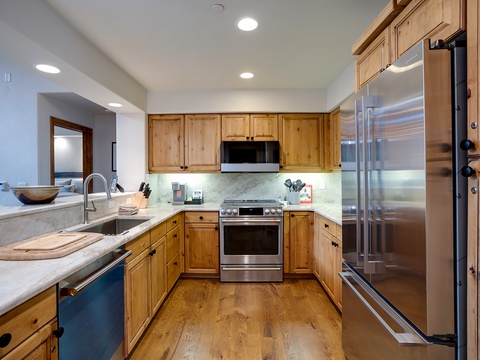Your fully equipped kitchen features warm wood cabinetry, sleek stainless appliances, and plenty of counter space for preparing home-cooked meals during your stay.