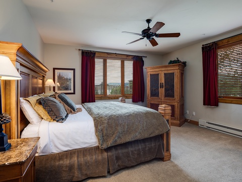 Slip into your peaceful retreat with a plush bed, warm wood furnishings, and soft natural light filtering through the windows. Your cozy escape awaits.