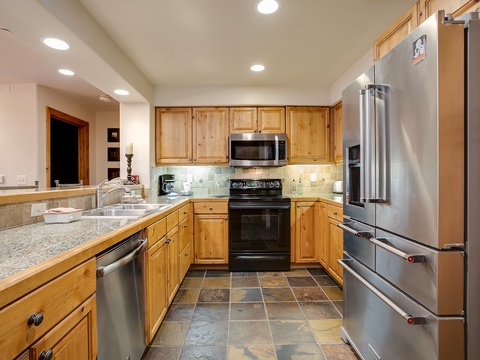Your fully-equipped kitchen features warm wood cabinetry, granite counters, stainless appliances, and ample space to whip up home-cooked meals with family and friends during your stay.
