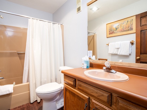 Your private bathroom features fresh towels, a convenient tub-shower combo, and plenty of counter space for your essentials—a cozy retreat after a day of exploring.