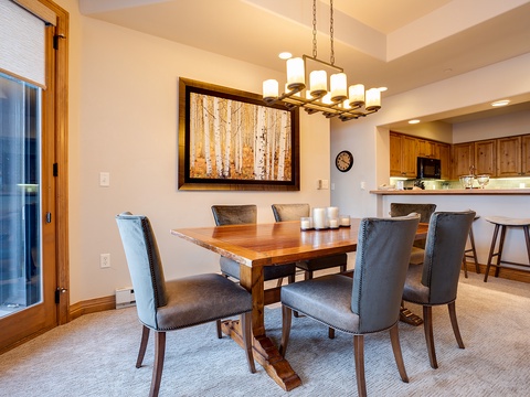 Gather around this inviting dining table where you'll share meals and memories with loved ones. The warm wood tones and soft lighting create the perfect atmosphere for your mountain retreat.