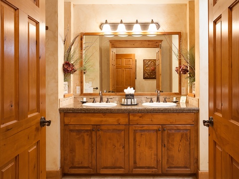 Step into your private bathroom oasis, where warm wood tones and elegant dual vanities invite you to freshen up in style and comfort.