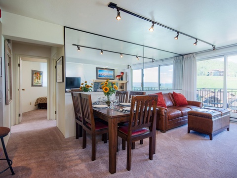 Relax in your open-concept living and dining space, where large windows frame stunning views. The leather sofa invites you to unwind, while the dining table awaits memorable meals together.
