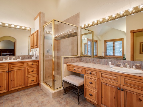 Pamper yourself in this spacious bathroom with dual vanities, bright vanity lighting, and a glass-enclosed walk-in shower—perfect for preparing for your mountain adventures.