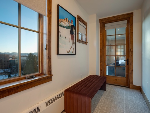 A welcoming entryway with ski-inspired art and natural light filtering through large windows, setting the tone for your mountain getaway with warm wood accents and cozy touches.