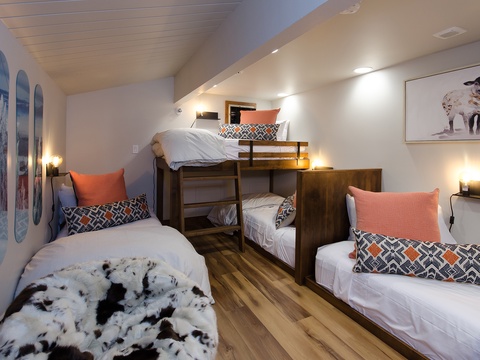 Cozy bunk room with rustic wood furnishings and ski-themed décor, perfect for families or groups sharing a mountain getaway together.