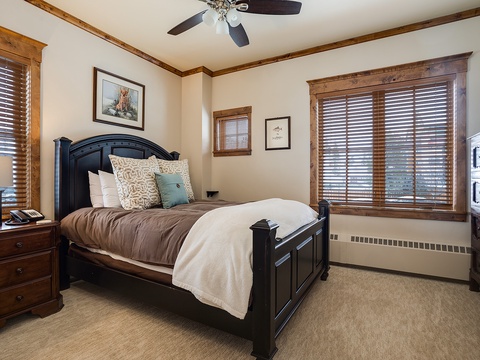 Unwind in your cozy bedroom, where rustic wood accents and plush bedding invite restful mountain nights. Natural light filters through, warming the space.