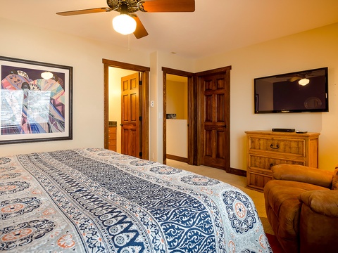 Unwind in your comfortable bedroom with a cozy bed, ceiling fan, flat-screen TV, and plush seating—your perfect retreat after a day of adventure.