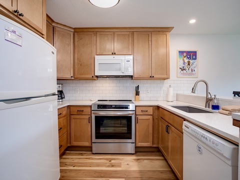 Your fully equipped kitchen makes meal prep a breeze, with modern appliances, ample counter space, and warm wood cabinetry creating a welcoming spot to gather and cook.