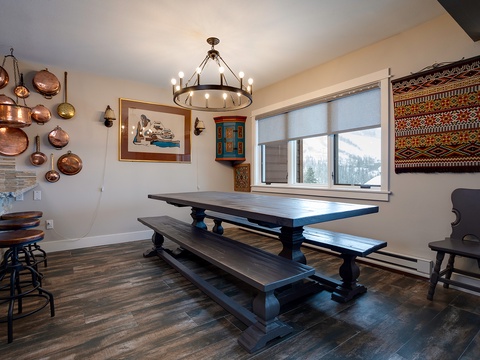 Gather around this rustic dining table where mountain views frame your meals and handcrafted details create an inviting space for shared moments and memorable conversations.