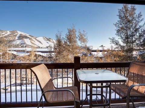 Sip your morning coffee on this private balcony, gazing at snow-dusted mountains and aspens framing a peaceful winter morning—a perfect alpine escape awaits.