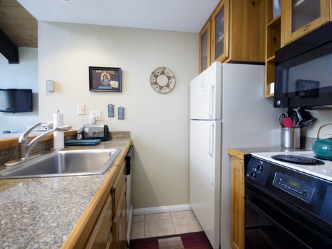 Your fully equipped galley kitchen has everything you need: stainless steel sink, full fridge, stove, and ample counter space to prepare your favorite meals during your stay.