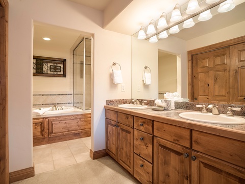 Unwind in your spacious en-suite with dual vanities, warm wood cabinetry, and a relaxing soaking tub—your private retreat after a day exploring the mountains.
