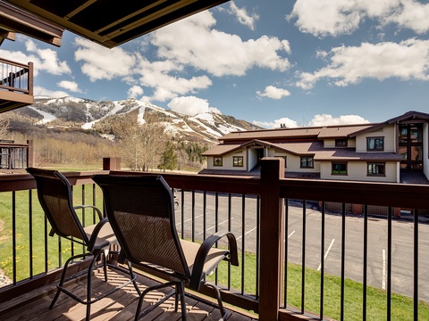 A mountain ski resort surrounded by residential condominiums and parking areas, offering seasonal winter activities and scenic alpine views in the background.