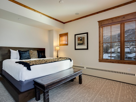 Rest easy in your serene bedroom with crisp white linens, elegant wood accents, and natural light filtering through to create your perfect mountain retreat.