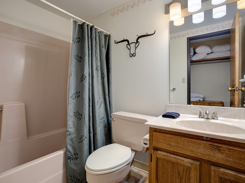 Your private bathroom features fresh towels, a tub-shower combo, and rustic Western touches—ready for you to unwind after a day exploring.