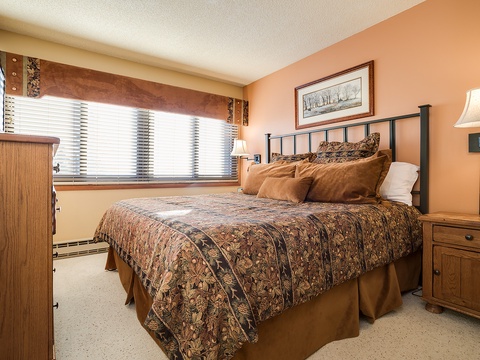Sink into this cozy bedroom where warm earth tones and soft natural light create your perfect mountain retreat. The plush bedding invites restful nights after your adventures.