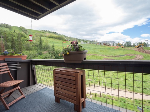 Private covered balcony overlooking lush mountain slopes with ski lift access, offering serene alpine views and a peaceful spot to unwind after your adventures.