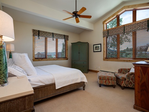 Sink into crisp linens and wake to mountain views in your peaceful retreat. The vaulted ceiling and natural light create an airy, restful atmosphere for your perfect getaway.