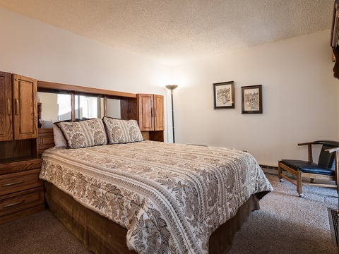 Settle into your cozy bedroom with its welcoming queen bed, warm wood accents, and soft lighting that makes unwinding effortless after a day of adventure.