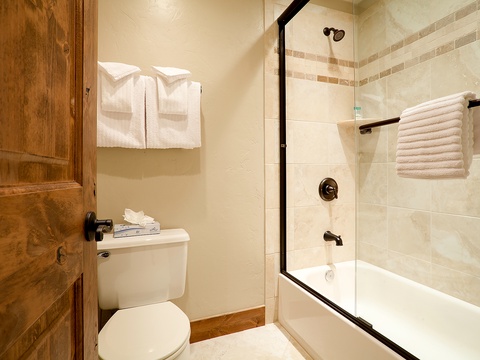 Step into your private retreat with fresh towels, a glass-enclosed tub-shower, and warm tiling that wraps you in comfort after a day of adventure.