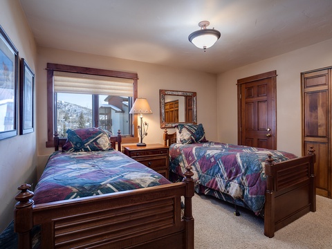 Relax in your cozy bedroom with two plush beds, rich wood furnishings, and mountain views through large windows that bring the alpine scenery right to you.