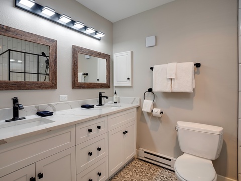 Freshen up in this bright, modern bathroom with dual sinks, stylish fixtures, and a walk-in shower. Plush towels and thoughtful touches make it your personal retreat.