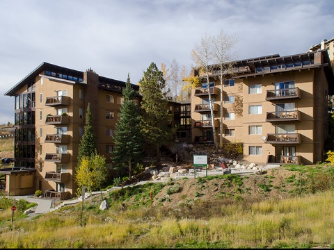 Multi-story mountainside property featuring private balconies and nestled among evergreens and aspens, offering direct access to the surrounding natural landscape.